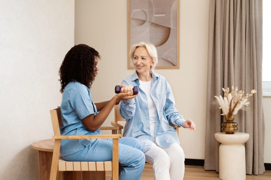 Ältere Frau macht zu Hause Physiotherapie mit einer Krankenschwester